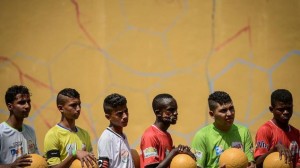 Los capitanes de los equipos de Pakistán, Brasil, Egipto, Burundi, Nicaragua y Mauricio (de izquierda a derecha) esperan en la banda en la segunda edición del Mundial de niños, en las calles de Rio de Janeiro, el 1 de abril de 2014.