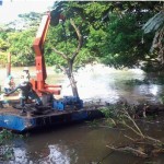 Costa Rica presentó esta foto que muestra a obreros de Nicaragua apartando troncos en el lado derecho del río San Juan.